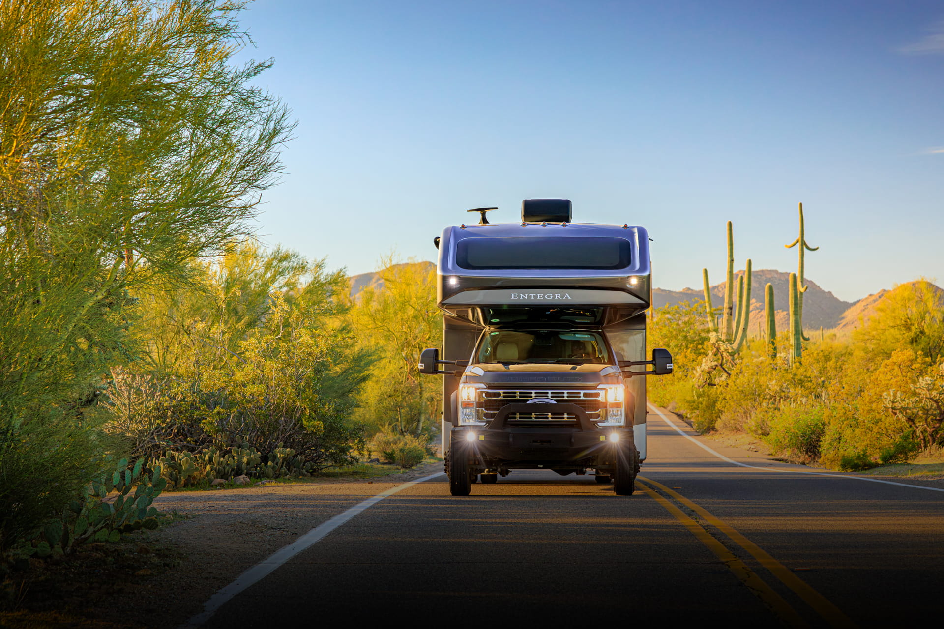 Entegra Coach Super C motorhome on desert road with mountains