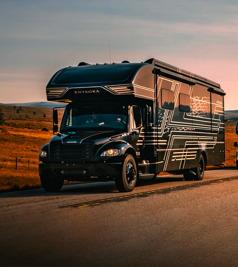Entegra Coach Class A motorhome on dirt road at dusk