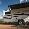 Entegra Coach Class C motorhome on road through forested mountains