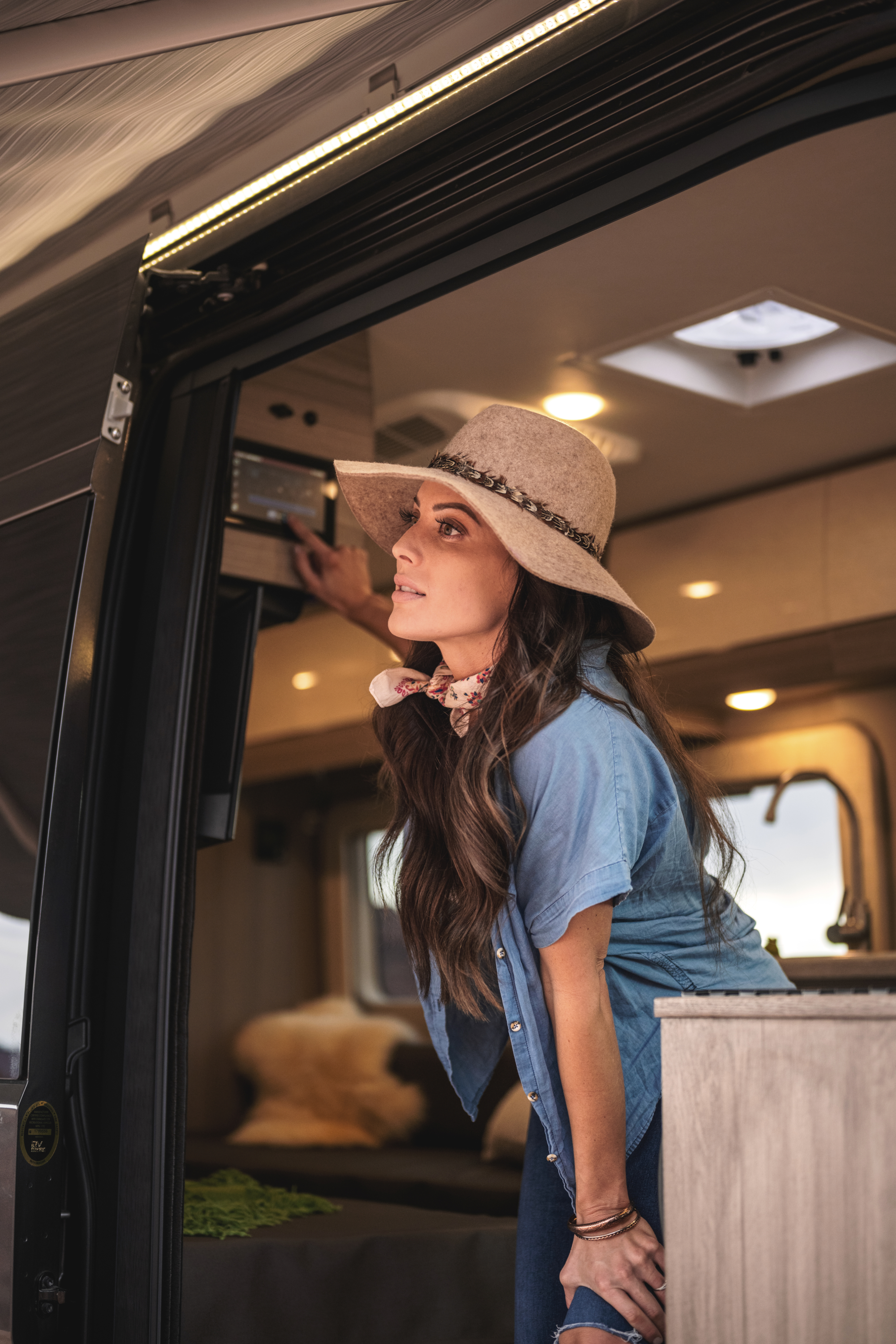 Entegra Coach owner in straw hat at side door of camper van